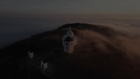 Aerial video footage of the Holy Hill in Mikulov. South Moravia in the Czech Republic. Around inversion low cloud cover.	