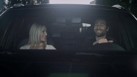 Front view. View through the front window of a car. The couple sits in the car, fastening their seat belts. The girl is having a conversation with the man. The couple is talking about the trip. - Powered by Shutterstock - Get 15% off with code: PIKWIZARD15