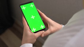 Woman doctor holding green screen chroma key smartphone vertical. Layout for mobile applications. Female in medical uniform show app on phone screen. Concept of programs and advertising for medicine - Powered by Shutterstock - Get 15% off with code: PIKWIZARD15