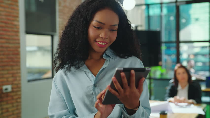Portrait of beautiful black woman using tablet and looking to camera with attractive smiling. Technology and Business concept. | Shutterstock HD Video #1101157969