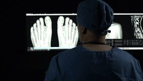 Surgeon in office looking at x-rays - Powered by Shutterstock - Get 15% off with code: PIKWIZARD15