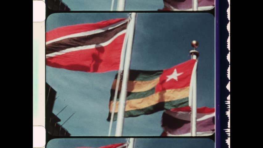1984 New York City, NY. Establishing shot of United Nations Headquarters. Close Up of national flags from several member nations of the UN. 4K Overscan of vintage archival newsreel film