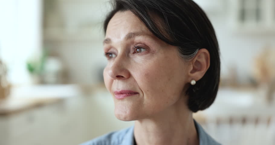 Thoughtful pretty mature woman looking away, turning face, looking at camera, smiling, thinking, posing. Attractive brunette lady, pensioner, older female model with natural makeup close up portrait | Shutterstock HD Video #1101167647