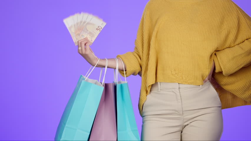 Shopping bag, cash and retail with hands of woman for spree, payment and luxury. Wealth, promotion and boutique with customer and money isolated on studio background for offer, bonus and discount