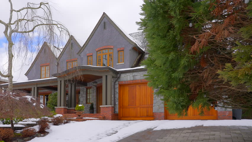Establishing shot of two story stucco luxury house with big tree and nice landscape at winter in Vancouver, Canada, North America. Day time on December 2021. ProRes 422 HQ.