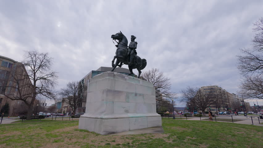 Washington, DC - USA - 02-20-23: The equestrian statue of General George Washington, sculpted by Clark Mills,  in Washington Circle on a winter day. Tilt down shot from the sky to the statue.