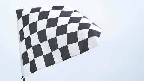 Checkered race flag waving in slow motion at finish line