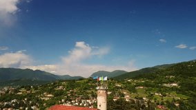 From top to down drone footage of the historical castle in the Brescia city. Lombardy, Italy (Summer sunny day, blue sky and waving flags on the main tower)