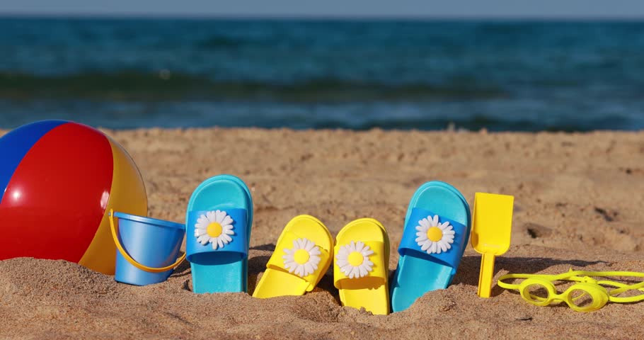 Beach flip-flops on yellow sand against blue sea and sky background. Summer vacation concept. Slow motion | Shutterstock HD Video #1101173319