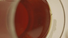 Milk is poured into a mug with strong black tea, vertical video