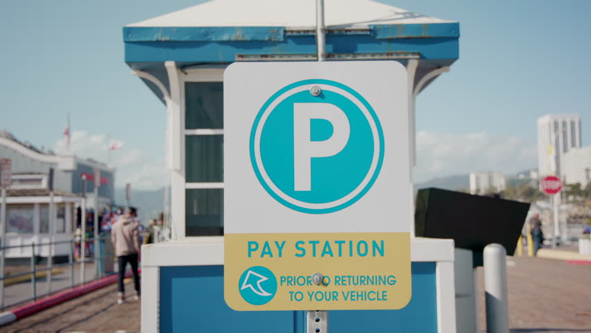 SANTA MONICA, LOS ANGELES, USA - MARCH 02, 2023: Pier bridge on beach. Santa Monica PAY STATION sign. Sunny day. Cars and vehicles pay station. High quality 4k footage