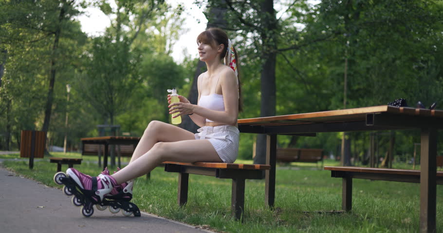 A girl rests on a park bench after playing sports