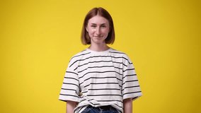 4k slow motion video of girl making telephone gesture near head call me sign on yellow background.