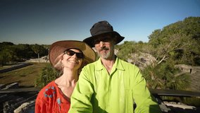 Mature couple takes a selfie among the stone ruins of the Maya at Xcambo historical park in Yucatan, Mexico near Telchac Puerto. Concept of adventure is ageless. - Powered by Shutterstock - Get 15% off with code: PIKWIZARD15