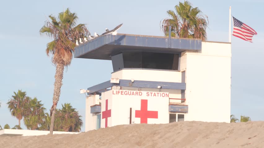Lifeguard stand, life guard tower hut, surfing safety on California beach, USA. Summer pacific ocean aesthetic. Rescue station, coast lifesavers wachtower or house, palm trees, Ocean Beach, San Diego.