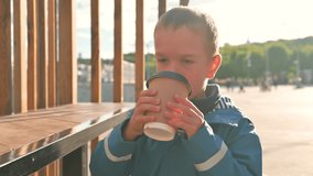 The boy drinking hot beverage with appetite.  4k video footage UHD 3840x2160 in slow motion