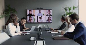 Diverse businesspeople take part in video conference call use application. Executives and group of multi-ethnic entrepreneurs, managers or investors engaged in virtual meeting. Modern tech, business