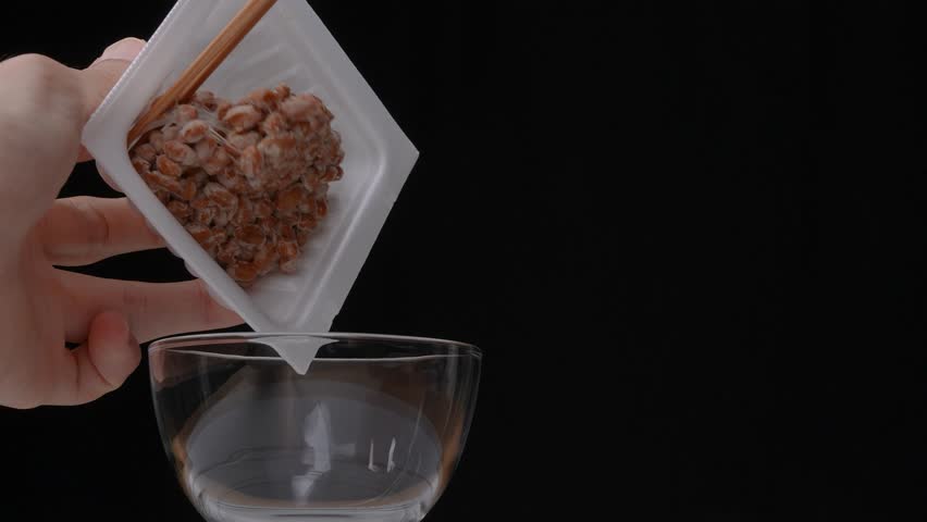 4k slow motion video of natto (fermented soybeans) being transferred from a pack to a glass container | Shutterstock HD Video #1101194717