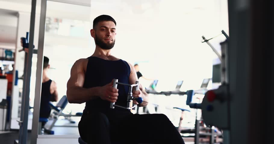 Man exercising at gym on the training apparatus