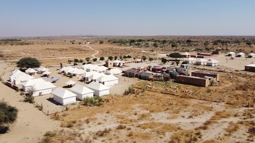 A luxurious camp stay located in the middle of Thar desert, surrounded by Sand dunes and layered with a beautiful sunset