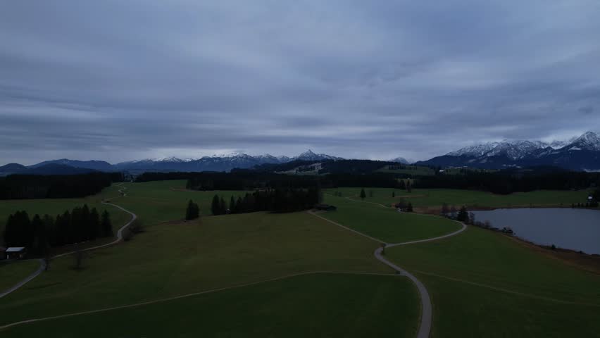 DRONE AERIAL FOOTAGE: Winter view from the Allgau Alps mountain range in the Northern Limestone Alps and alpine lake Attlesee, located near Nesselwang town, Bavaria, Germany.