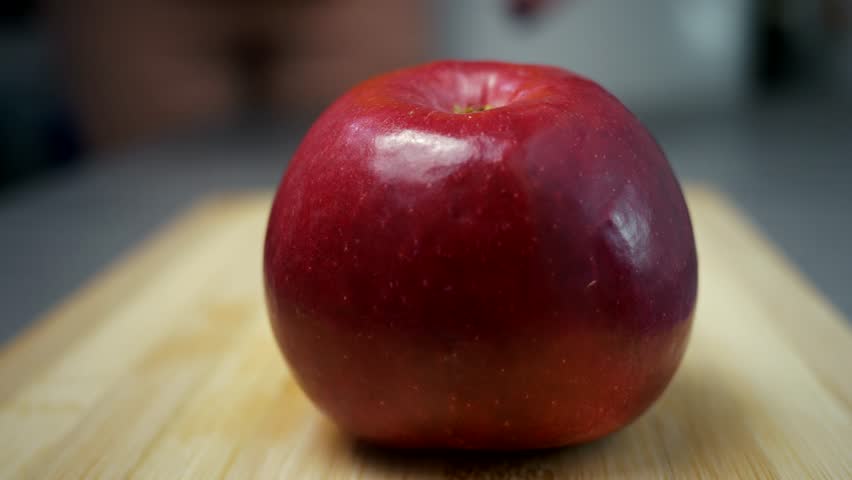 A girl cuts a red apple in half with a large knife. Close-up. Ripe fruit cutting. The use of vitamins. Fruit diet. Royalty-Free Stock Footage #1101207729