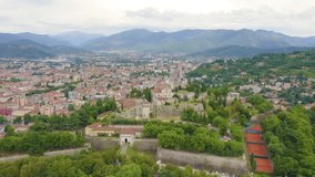 Inscription on video. Brescia, Italy. Castello di Brescia. Flight over the city in cloudy weather. Shimmers in colors purple, Aerial View, Point of interest