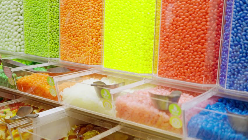  Young girl, chooses multi-colored colourful sweets, lollipops, caramels from a large selection. Lifestyle of choice, life, love for sweets | Shutterstock HD Video #1101215193