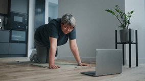 Healthy Aged Woman Training At Home By Video Tutorial In Internet, Stand On Knees And Hands On Floor