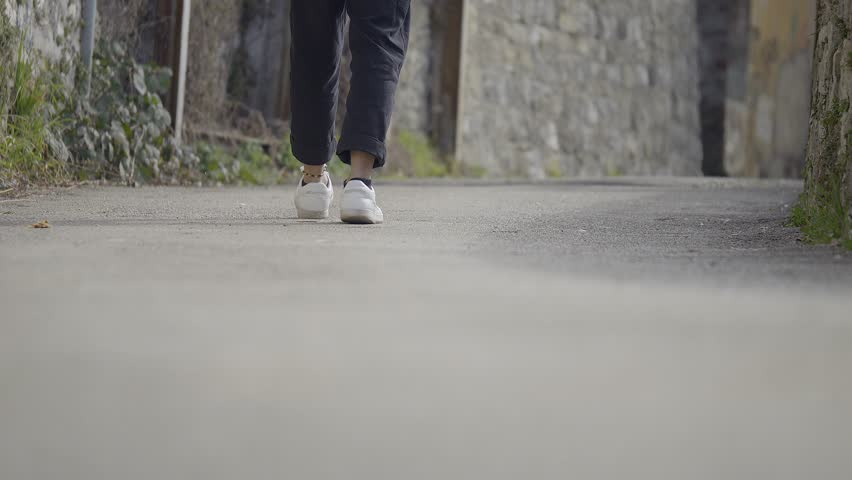 Ground Shot Of Young Teenager Foot Steps Wearing Casual Shoes And Anklet | Shutterstock HD Video #1101218485
