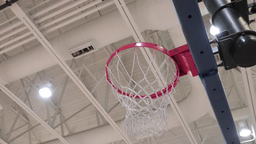 Basketball going into hoop after someone shoots the ball.
