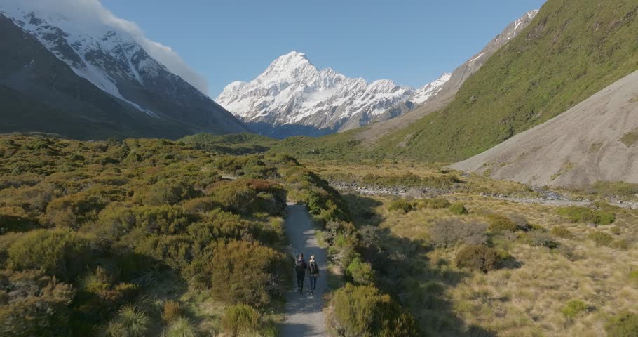 Couple hiking on Hooker valley trail with stunning view of Mount Cook, aerial