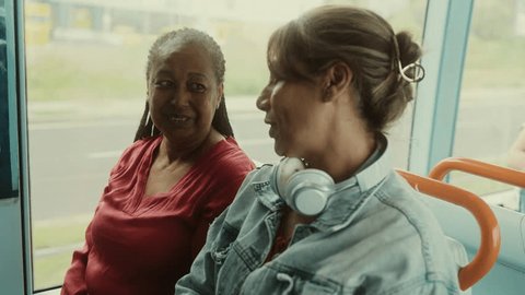 Happy multiracial women talking while traveling in the bus स्टॉक व्हिडिओ