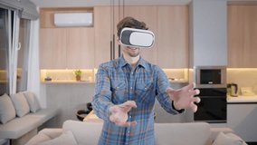 Young man playing at home, having fun, studying, working using a virtual helmet. A young man wearing glasses and a virtual reality helmet. Young woman uses VR. - Powered by Shutterstock - Get 15% off with code: PIKWIZARD15