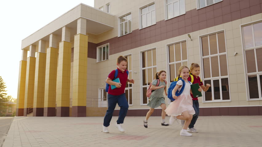 child boy girl run with school backpacks school. happy cheerful children playtime children's yard. kid child running school class for lesson. students first graders running smiling school bags backs. Royalty-Free Stock Footage #1101225117