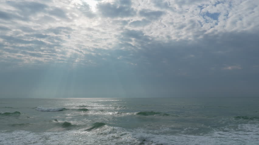 silver light as it reflects on waves in wild sea during dramatic morning