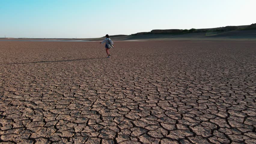 Shooting from a drone walking along a dried lake girl