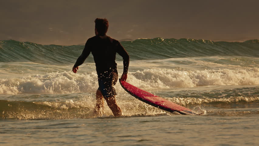 Surfer walks with surfboard on the beach at sunset. Brazil Royalty-Free Stock Footage #1101227375