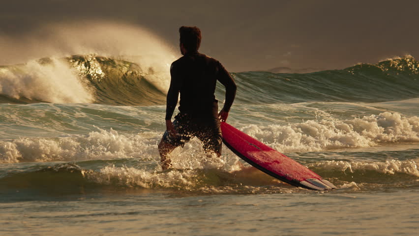Surfer walks with surfboard on the beach at sunset. Brazil | Shutterstock HD Video #1101227375
