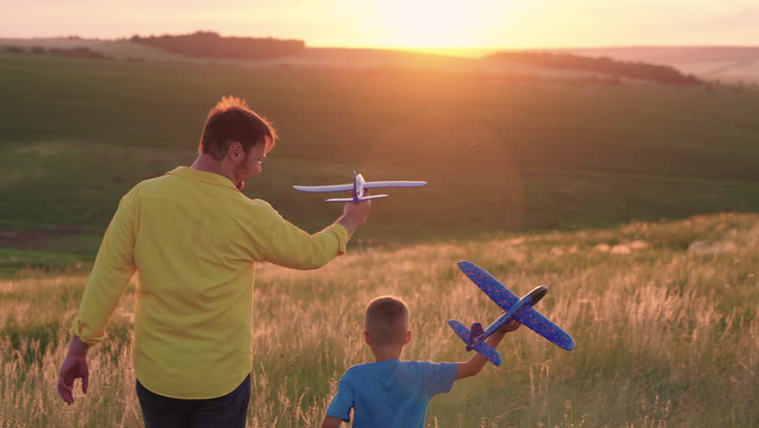 Happy family, child, dad with an airplane play together at sunset in park. Son, father Dream of becoming pilot. Teamwork dad, kid, aviators. Boys childhood dream fly. Toy plane in hand, in sun. Nature Royalty-Free Stock Footage #1101228847