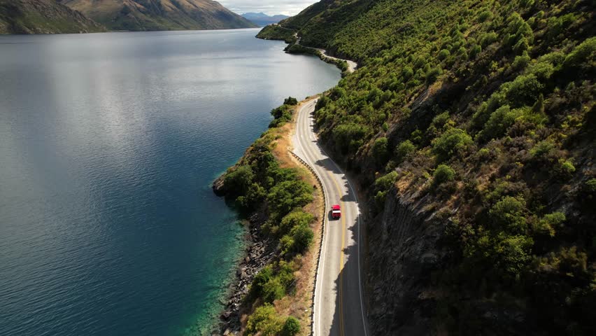 New Zealand road trip. Beautiful scenic aerial of winding road, Lake Wakatipu, Queenstown. Royalty-Free Stock Footage #1101229253