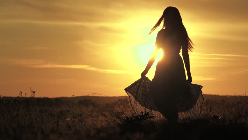 Silhouette of girl dancing on grass. Happy young woman dancing in spring on field in sunshine. Beautiful girl in white dress is having fun in summer outdoors, sunset. Concept of feminine dreams, joy. | Shutterstock HD Video #1101230427