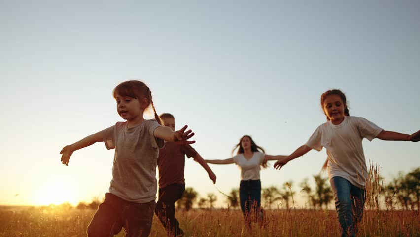 Silhouette of children run and playing in park. children run in park at sunset. Kids run in grass silhouette. children playing outdoors silhouette lifestyle. Kids playing in the park at sunrise | Shutterstock HD Video #1101230753