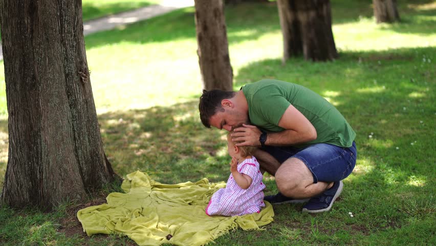 Dad comforts a crying little girl and takes her in his arms