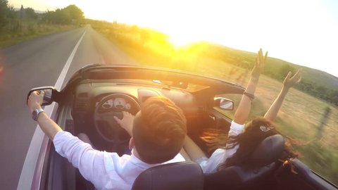 Couple driving convertible car cabriolet steadicam shot. UHD 4K stock footage