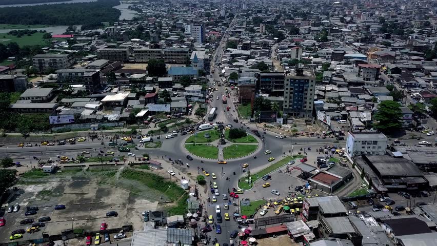 Aerial view of Rond-Point Deido roundabout, towards a industrial area in Douala city, Cameroon - pan, drone shot Royalty-Free Stock Footage #1101238499