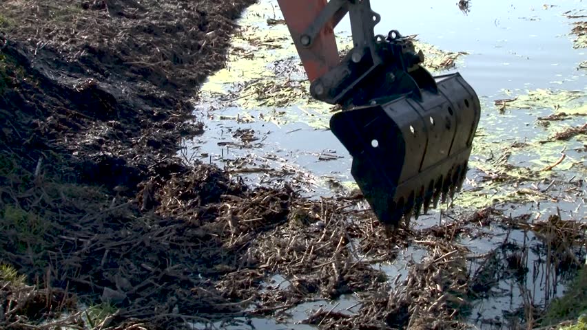 Bucket dredging machines: lifting the soil from the bottom of the river
excavator dredge is dredging, working on river, canal, deepening and removing sediment, mud from riverbed in a polluted waterway Royalty-Free Stock Footage #1101239921