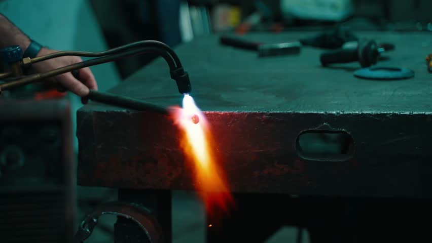 A blacksmith heats a billet with a gas burner before forging | Shutterstock HD Video #1101240587