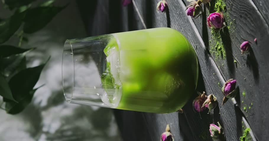 Preparing matcha latte, pouring milk in a glass with green tea and ice cubes, preparing a cool refreshing drink with powdered green tea, slow motion close-up video, high quality 4k footage Royalty-Free Stock Footage #1101240597