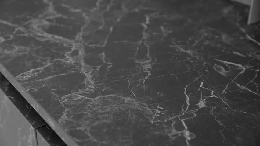Close-up shot of beautiful granite black and grey counter top, camera moving slow motion. Kitchen design with counter top made of granite stone. Texture and background. Royalty-Free Stock Footage #1101242409